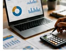Laptop and calculator with business charts on a desk